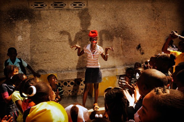 Port au Prince, Haiti. My-Taelle does a clown routine in front of a group of children. My-Taelle is 10 years old. She lives with her mother, two brothers and four sisters. Her father left the family home. My-Taelle in in fifth grade. Like many other children in Haiti she wasn't able to go to school following the 2010 earthquake. She was happy to be back at school when a temporary classroom was set up because this seemed like normality was returning to her life. "I dream of becoming a clown. I'll be able to make other children happy. Many people were sad after the earthquake because they lost family members or their houses. I'm glad that I can make people laugh."